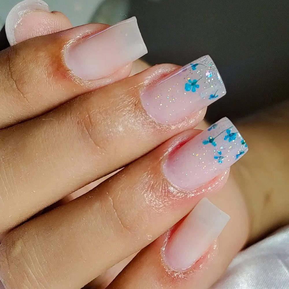 Nail art delicada com flores azuis